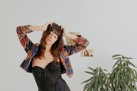 a model wearing modern secondhand corset, vintage nineties jacket with a bold pattern and pleated pants