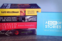 Brown box filled with fiction books, showcasing a variety of gripping titles and intriguing covers, perfect for mystery lovers.