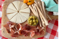 Serrano Tapas Box featuring goat cheese 'Murcia al vino', Serrano ham, breadticks and anchovies stuffed olives.