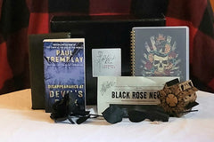This is a picture of the book titled Disappearance at Devil's Rock, the book wrapped in paper, newsletter, Hellraiser puzzle, and other gift