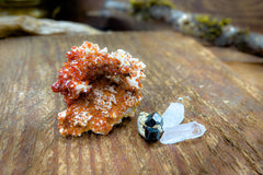 Enchanted Crystal subscription box on wooden table, with single featured crystal of the month and bonus mini crystals