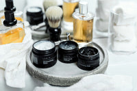 High quality photo of mens spa and self care, skin care products. Three of them are opened and there are many more in the background.