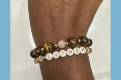 Handmade encouragement bracelet with earthy brown stone beads, amber faux crystal accents, and white letter beads spelling “ENOUGH” 