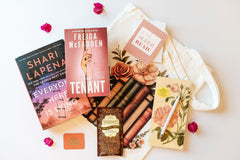 A customizable book subscription box featuring two novels, a tote bag, and bookish items for readers