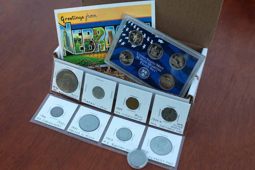 Coin Collectors box with state quarters proof set, Nebraska post card, Eisenhower dollar, Japanese Yen, and more. 