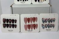 Multiple press-on nail sets arranged on branded display cards labeled nail art, highlighting different color themes and cohesive design coll