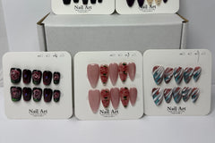 Multiple press-on nail sets arranged on branded display cards labeled nail art, highlighting different color themes and cohesive design coll