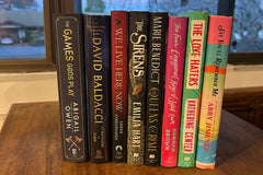 A stack of hardcover books that are not yet available in paperback. Romance, Suspense, and Romantasy books.