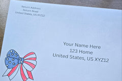 White envelope with printed sample U.S. mailing and return addresses, featuring a red, white and blue patriotic bow with stars and stripes.