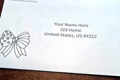 White envelope with printed sample U.S. mailing address and a black outline patriotic bow design with stars in the lower-left corner.