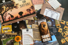 An unboxed picture of "Escape on Safari" showing papers, props, and puzzles used when playing the game.