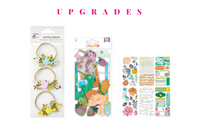 Colorful scrapbook papers and stickers in a monthly scrapbook kit featuring floral designs and cameras, ideal gifts for women