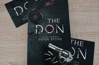 Black cover with a revolver in the bottom right corner. The title The Don appearing in the center. Loose rounds appear next to the revolver.