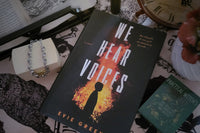 This is We Hear Voices by Evie Green with a skull bracelet gift and a witch's spell card box. There is partial book showing in corner 