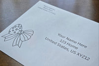 White envelope with printed sample U.S. mailing and return addresses, featuring a black outline patriotic bow with stars on the left.
