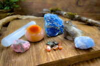 Enchanted Crystal subscription box on wooden table, with multiple crystals arranged and bonus mini crystals
