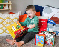 Happy toddler enjoying Owl Post Books kids subscription box with holiday gift books, perfect Christmas present for young readers.