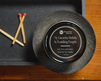Introverts Read & Relax box contents - close up of a candle on a tray with matches. All on a wood table.