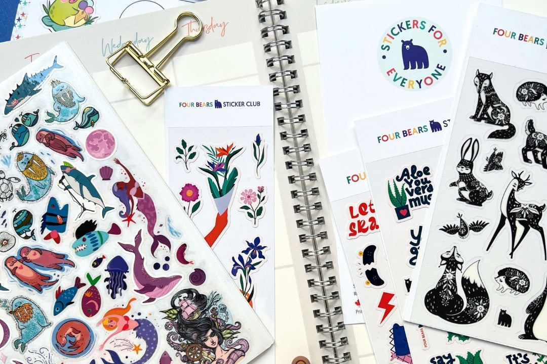 A tidy desk featuring an open monthly planner with colorful decorative sticker sheets displayed beside it, perfect for personalizing and org