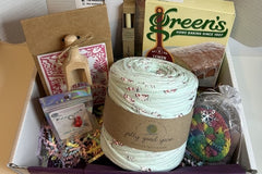 Box contents for Hygge themed box with a giant ball of yarn, lemon drizzle cake, bath salts and more.