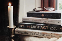 Brown subscription box filled with four surprise fiction books, offering captivating stories and diverse plots for literature lovers.