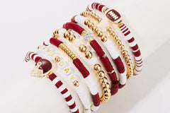 Game Day 8-piece stackable friendship bracelet set in maroon, white, and gold beads displayed wrapped diagonally around a white cylinder sta