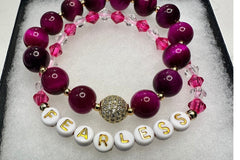 Handmade encouragement bracelet with soft pink stone beads, rose faux crystal accents, and white letter beads spelling “FEARLESS” 