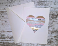 Greeting card and envelope with a torn paper art heart on the front of it. The heart has layers of pink, gold and patterned paper.