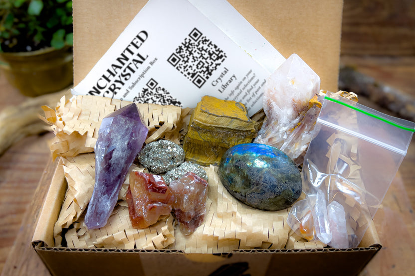 enhanted crystal subscription box, open box, showing several crystals and a card in the background, packaged with recycled materials