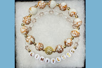Handmade encouragement bracelet with white stone beads, clear faux crystal accents, and white letter beads spelling “LIMITLESS” 