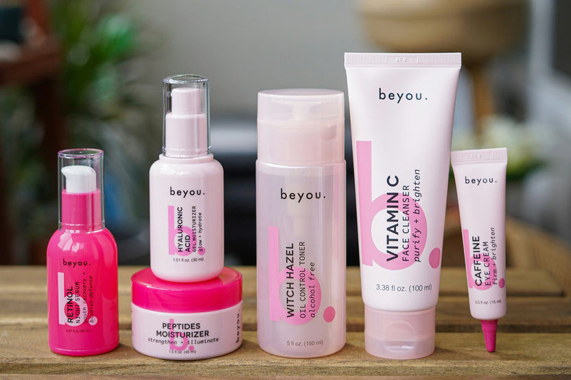 pink products standing on a wooden shelf with a cozy room in the background. All the products are pink.