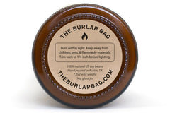 Bottom of a 9oz Burlap Bag amber jar with the kraft safety sticker: 100% natural US soy, hand poured in Austin, 7.2oz wax