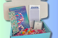 Sample boxes displayed on a crate, showing books, self care items, homeware, information cards, crafts and more