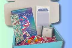 Sample boxes displayed on a crate, showing books, self care items, homeware, information cards, crafts and more