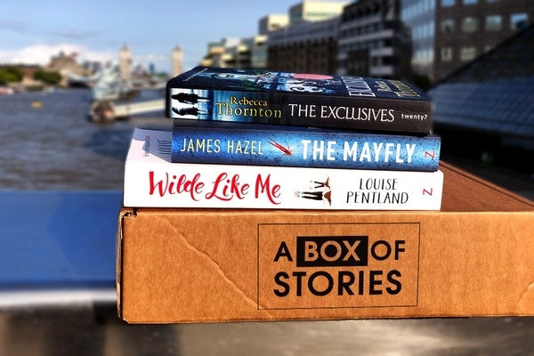Brown box filled with fiction books, showcasing a variety of gripping titles and intriguing covers, perfect for mystery lovers.