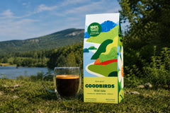 Two bags of coffee, a Goodbirds box and a cup of coffee, part of Goodbirds monthly coffee subscription of 2 12oz bags of coffee