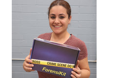 A blue box containing a forensikit is displayed in the the hands of a woman with dark hair.  she is smiling