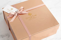 Outside packaging. Magnetic box, hand tied grosgrain ribbon with gold foil logo and gold foil gift tag. 