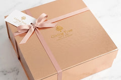 Outside packaging. Magnetic box, hand tied grosgrain ribbon with gold foil logo and gold foil gift tag. 