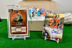 Baltimore Orioles relic and autographed baseball cards arranged in display stands on a green carpet and with inserts in a box.