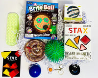 Teen Sensory Box has Brite Ball, Weighted Snake, Stax Magnetic Blocks, Land of Dough, Snapperz, Pencil Case Bubble Pop, Needo,h, Puffer Ball
