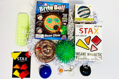 Teen Sensory Box has Brite Ball, Weighted Snake, Stax Magnetic Blocks, Land of Dough, Snapperz, Pencil Case Bubble Pop, Needo,h, Puffer Ball