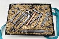 Gift box with chocolate tool set including wrenches, pliers, screws, nuts, and a file, crafted as realistic edible treats