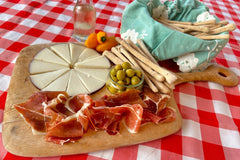 Serrano Tapas Box featuring goat cheese 'Murcia al vino', Serrano ham, breadticks and anchovies stuffed olives.