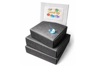 Stack of closed GemFlip black boxes on a white background with a faceted gemstone placed on top, highlighting premium packaging for gemstone