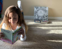 Preteen reading beside an Owl Post Books kids subscription box filled with Baby Animals and crafts, a perfect holiday gift for tweens.