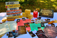 Sample of one of our previously released mysteries shown on a table with the journal, evidence, and clues on a table.