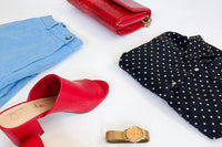 red mules with a linen blue short and navy polka dot shirt along with a gold watch and matching red clutch