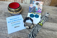 Box of Blessings featuring Africa: woven disc earrings, bone bracelet, safari leather bookmark, carved bowl