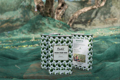 3 tins of 100% Italian extra virgin olive oil sitting on olive capture nets from the annual harvest. 
